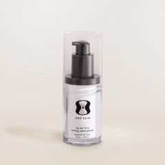 Clear bottle with black pump and 'One Skin' label on a light beige background