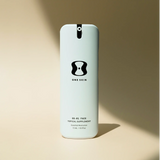 Skincare bottle labeled 'ONE SKIN' on a beige background